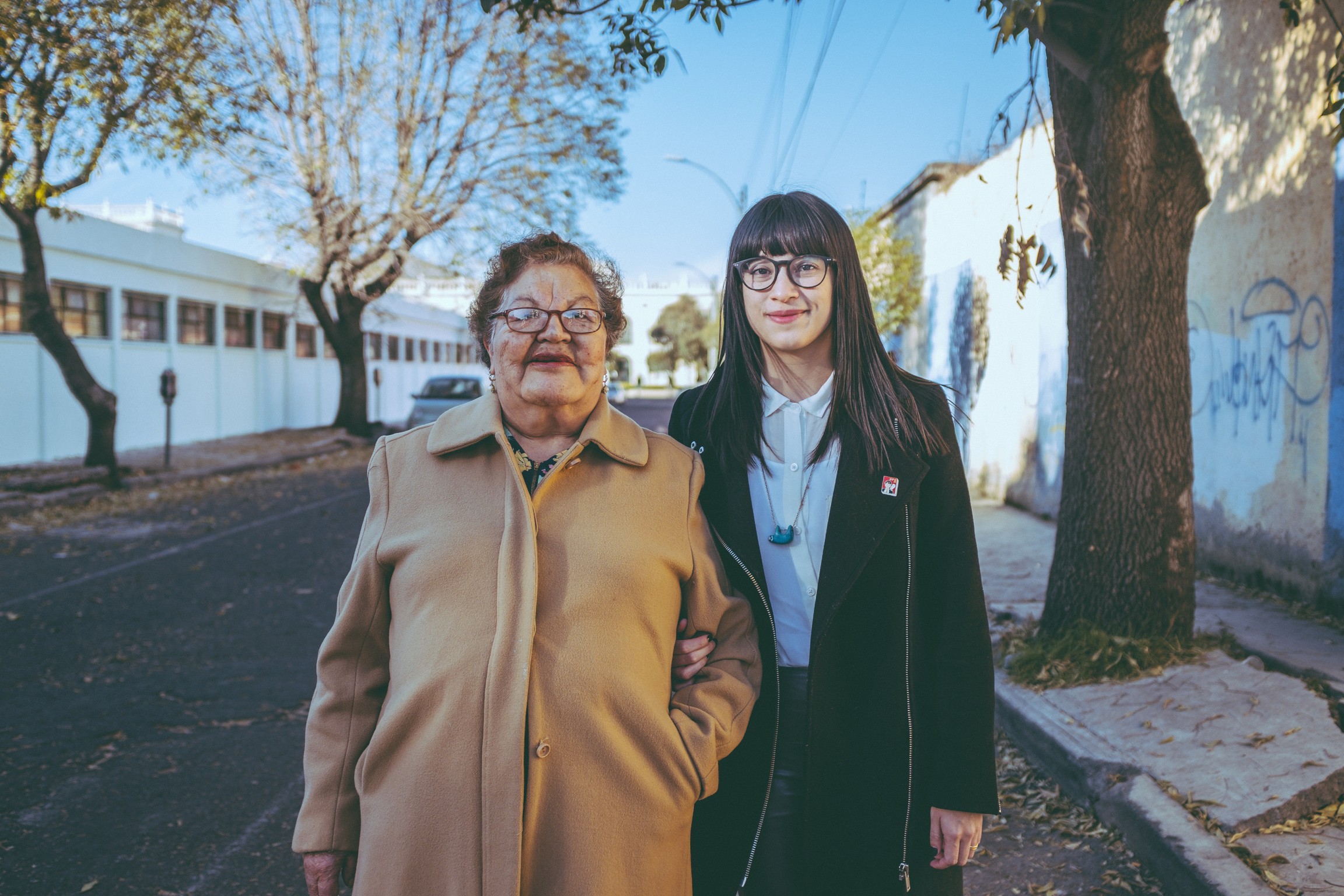 Daniela y su abuela caminando juntas, tomadas del brazo, en la calle en Toluca, México