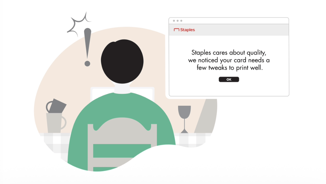 Storyboard frame showing a customer using the Staples website, which is displaying a print quality warning